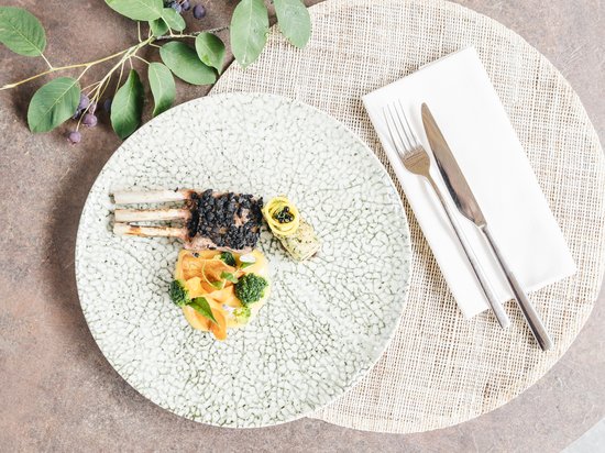 Kraftplatz am Schlern und himmlischer Genuss: Restaurant Anima Gourmetgericht mit Lammkoteletts, Gemüse und dekorativem Besteck