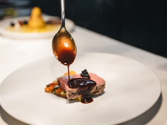 Genussurlaub in Südtirol – Sensoria Dolomites Sauce wird auf ein Stück rosa gebratenes Fleisch mit Gemüse geträufelt