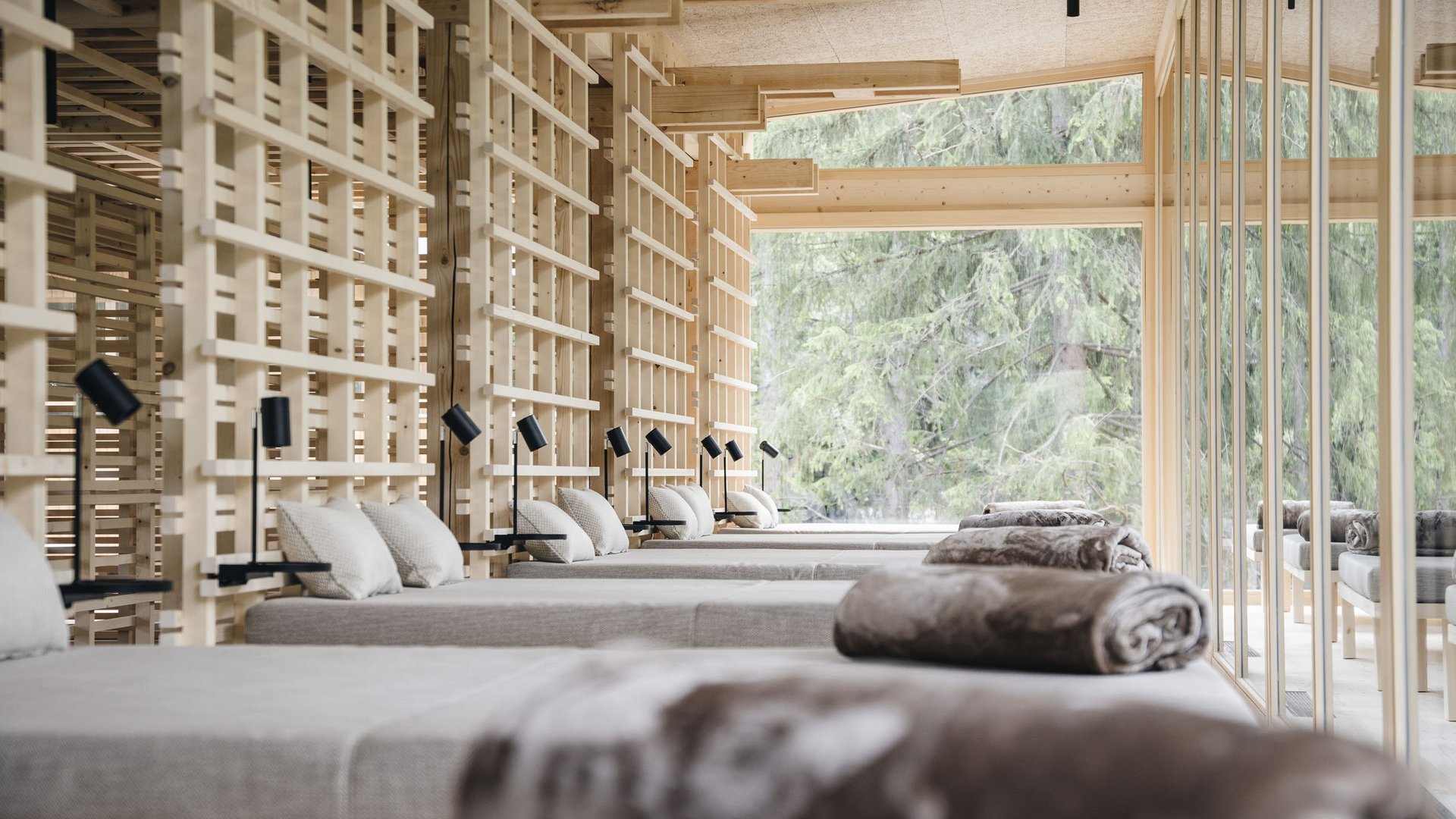Wellness Aphrodite: Sensoria Dolomites unter den Siegern Ruheraum mit Liegen, Kissen und großen Fenstern mit Blick auf Bäume