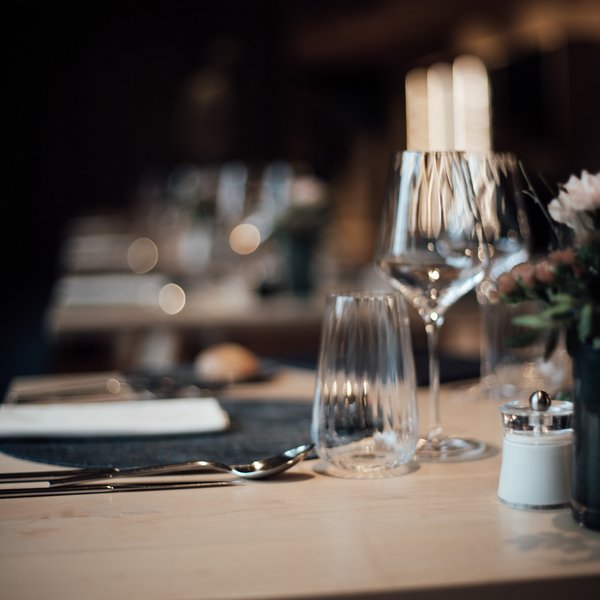 Genussurlaub in Südtirol – Sensoria Dolomites Elegante Tischdekoration mit Glas, Besteck und Gewürz im Restaurant