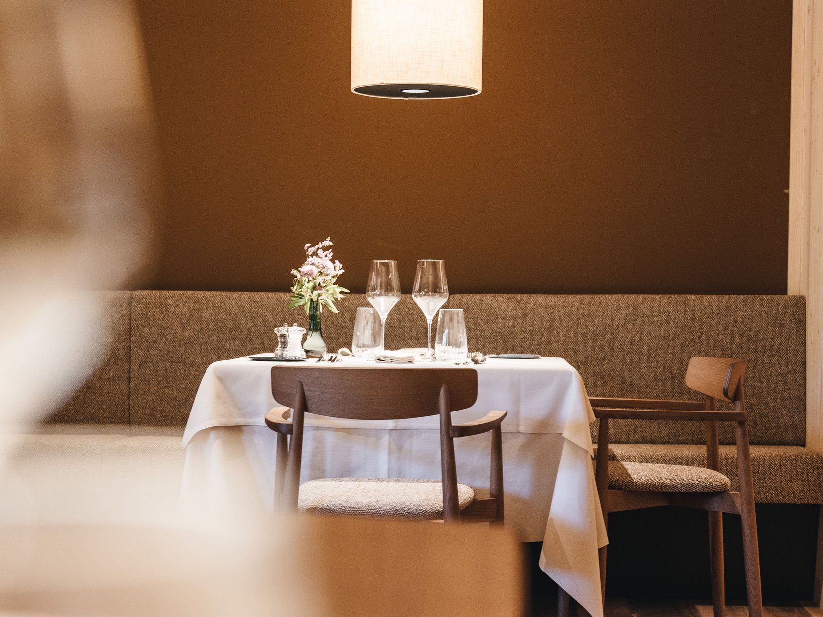 Sensoria Dolomites: Wellnesshotel in den Bergen Romantisch gedeckter Esstisch mit Blumendekor unter Hängelampe