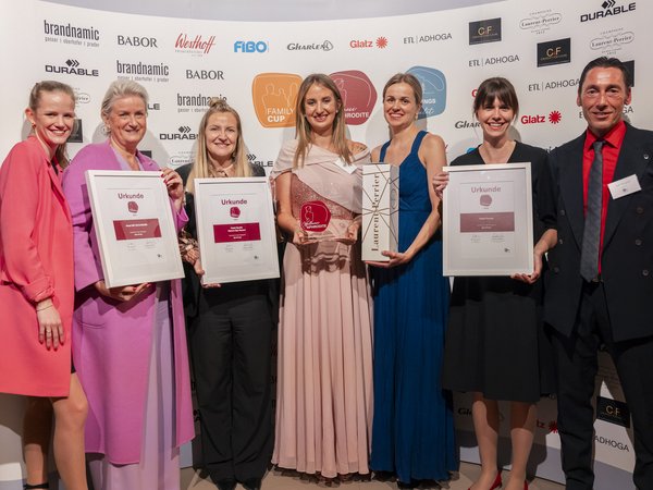 Wellness Aphrodite: Sensoria Dolomites unter den Siegern Sieben Personen posieren mit Urkunden und Auszeichnungen bei einer Preisverleihung.