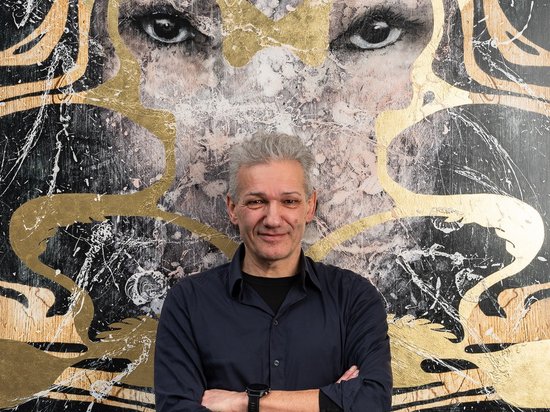 My Olympic Mindset Retreat 2026 Mann vor großem Kunstwerk mit Augen und olympischen Ringen in Gold