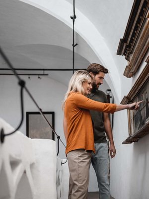 Sensoria Art Edition 01 Paar betrachtet und zeigt auf ein Gemälde im Museum mit weißem Innenraum