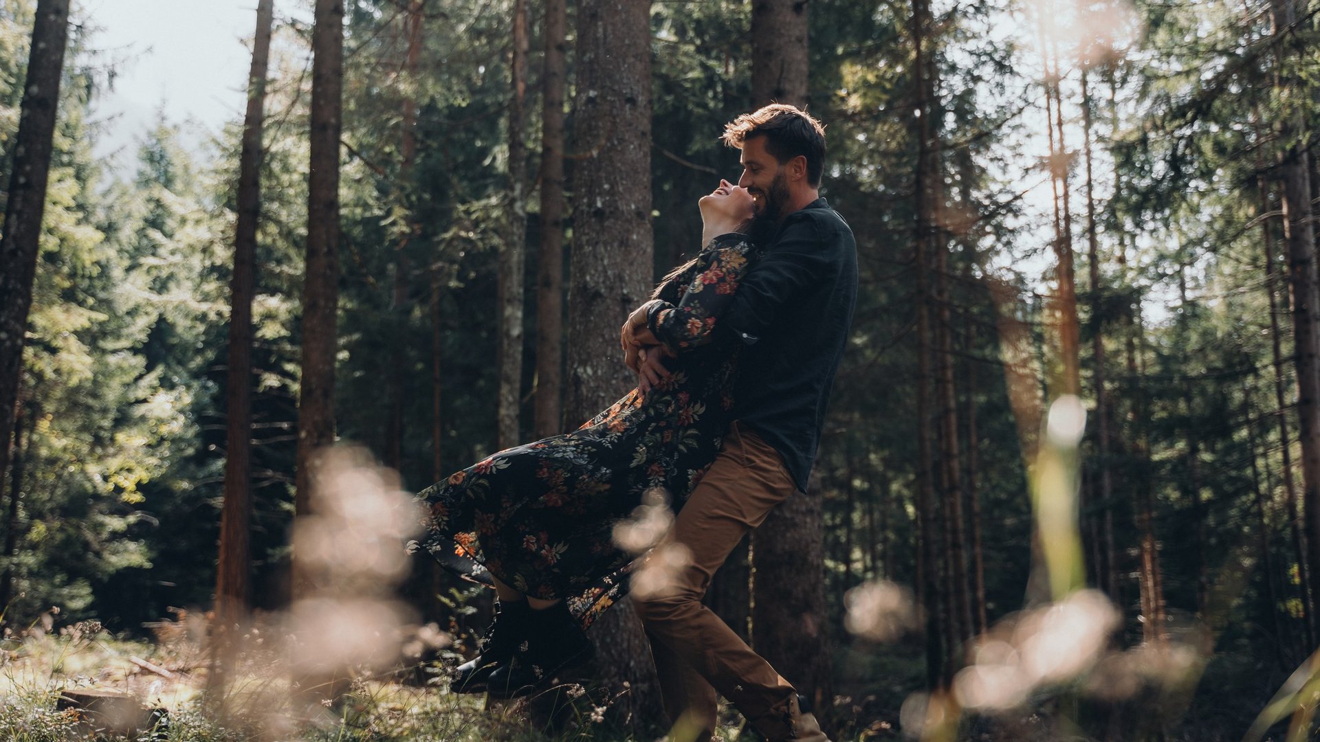 Kostbare Augenblicke in Ihrem Romantikhotel in den Dolomiten Glückliches Paar umarmt sich im Wald bei Sonnenlicht