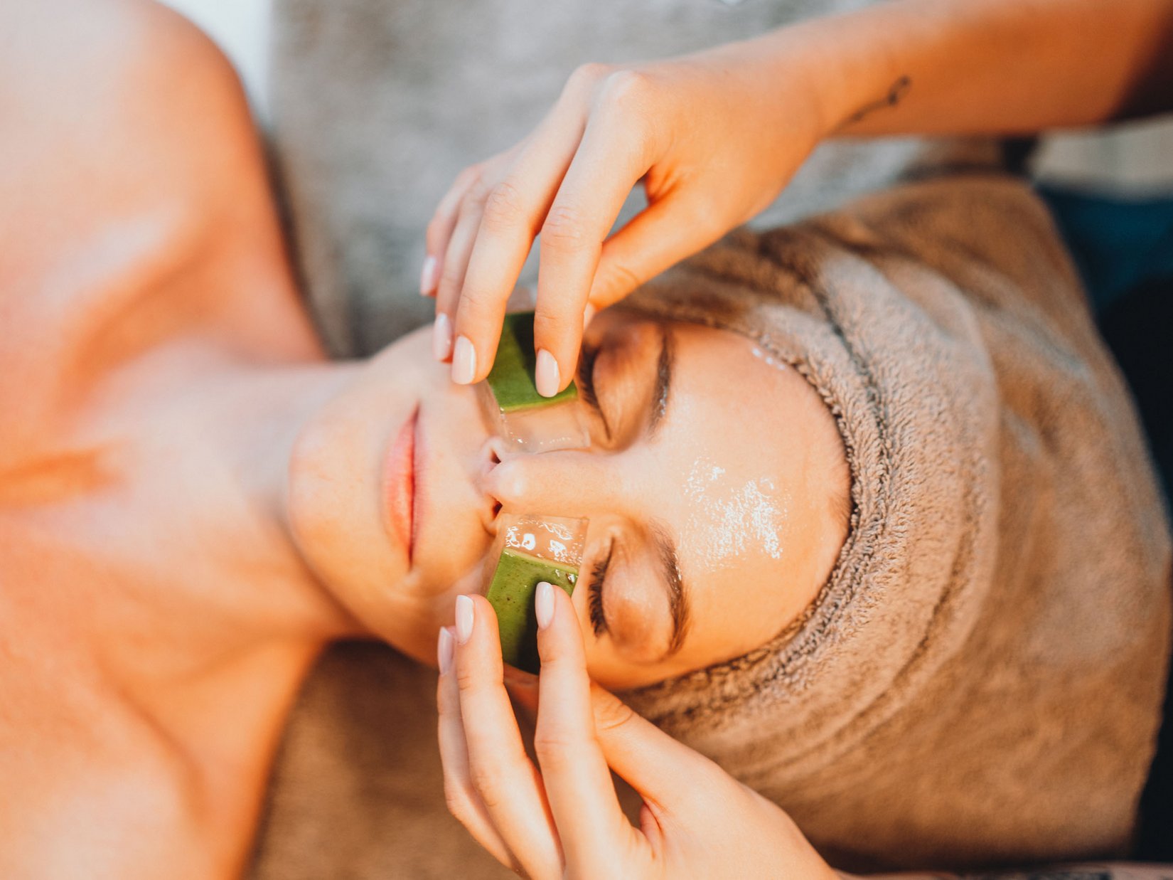 Momente, die bleiben. Im Luxushotel auf der Seiser Alm. Frau mit Aloe-Vera-Gel unter den Augen während einer Gesichtspflege