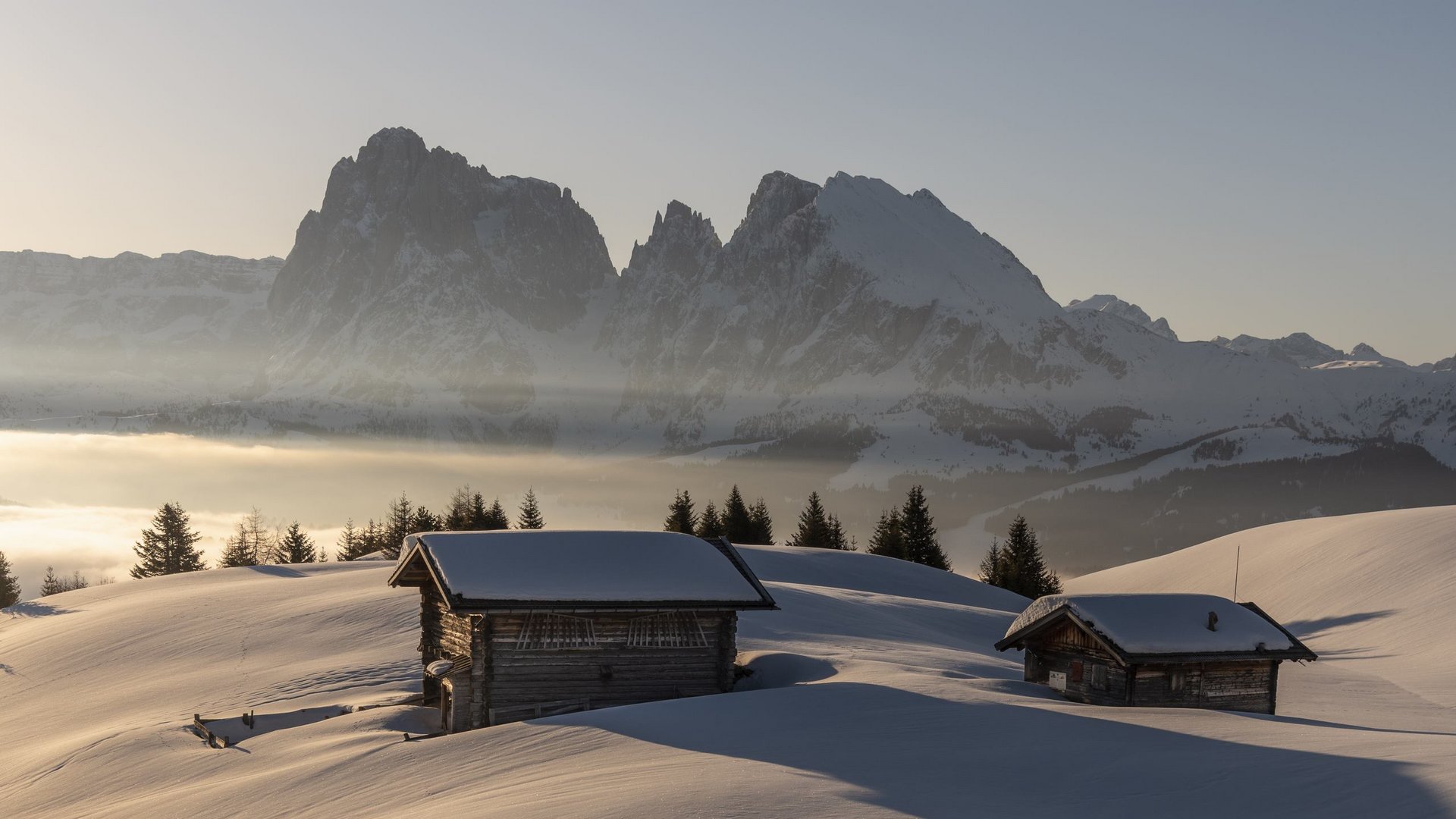 Silvester in den Bergen Verschneite Hütte vor Bergen bei Sonnenaufgang