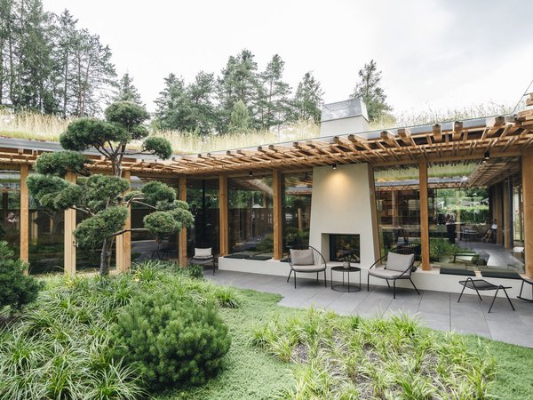Wellness Aphrodite: Sensoria Dolomites unter den Siegern Moderner Garten mit Terrasse, Kamin und Holzpergola umgeben von Bäumen