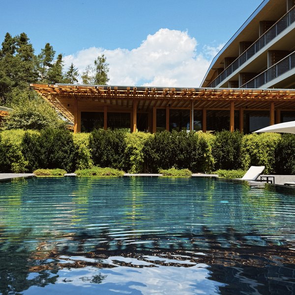 Von Wanderungen auf der Seiser Alm in die Spa Area Außenpool mit Liegestuhl und moderner Architektur bei sonnigem Wetter