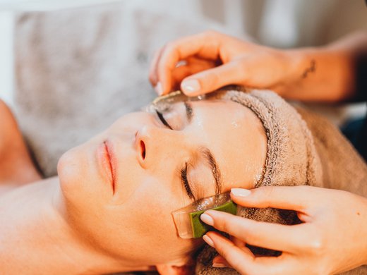 Inclusive services – last-minute South Tyrol holidays Woman receiving facial massage with gel and aloe vera pieces