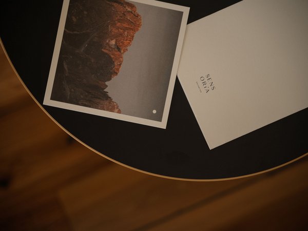 Downloads – Infos rund um den Naturpark Schlern-Rosengarten Foto und Karte auf rundem Tisch mit dem Text Sens Oria Dolomites