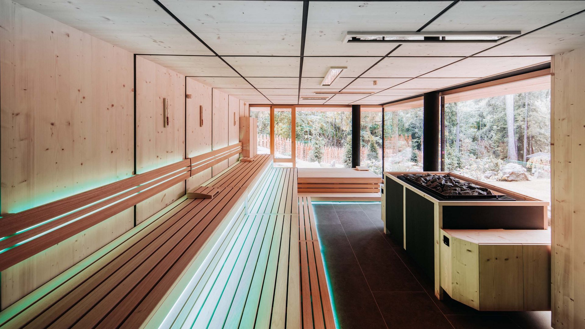 Day Spa in Südtirol – Wellness für die Seele Moderner Saunaraum mit großen Fenstern und Holzbänken
