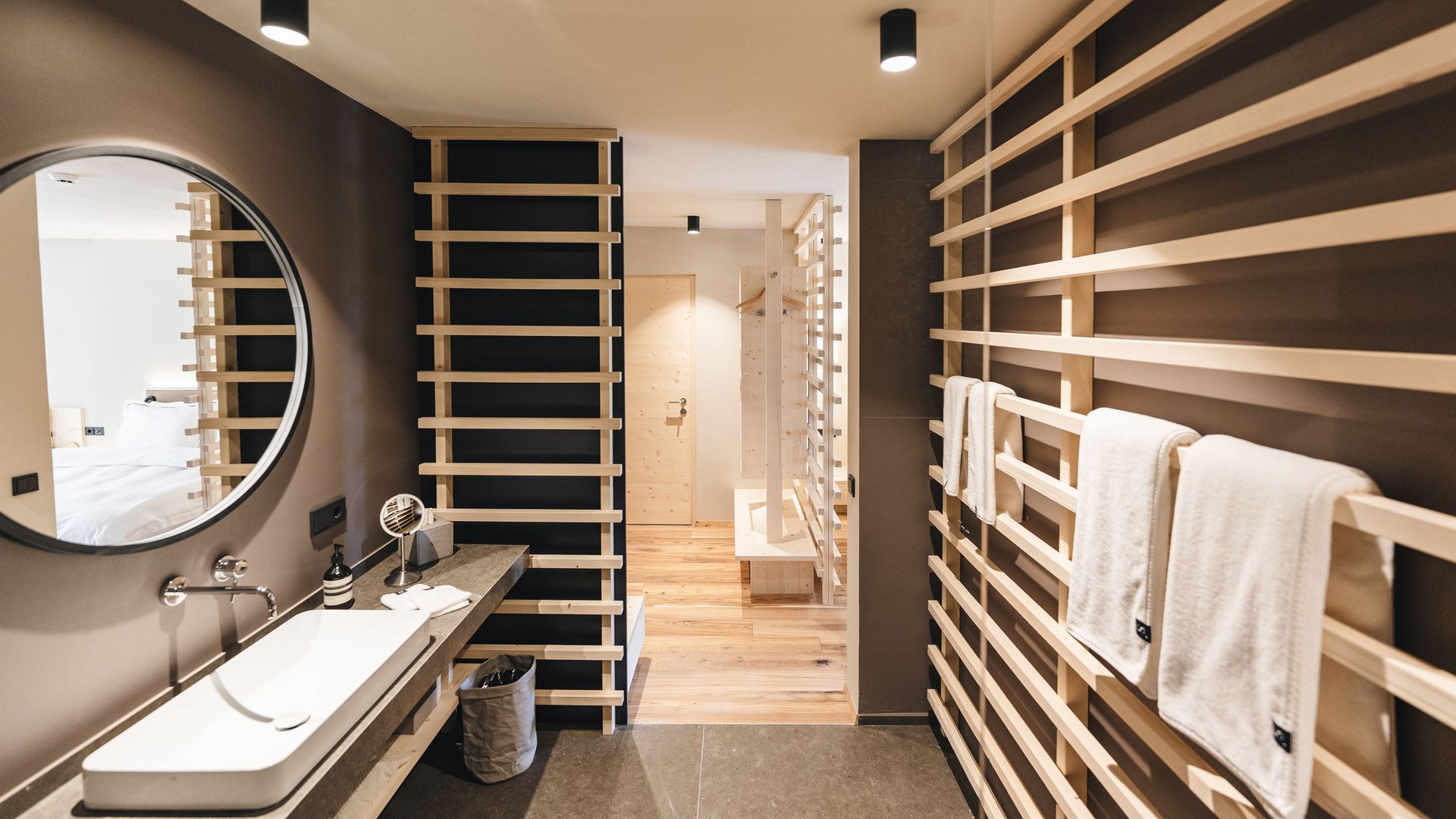 Ort der Kraft – Ihr Lieblingszimmer Modernes Badezimmer mit rundem Spiegel und Holzpaneelen an den Wänden