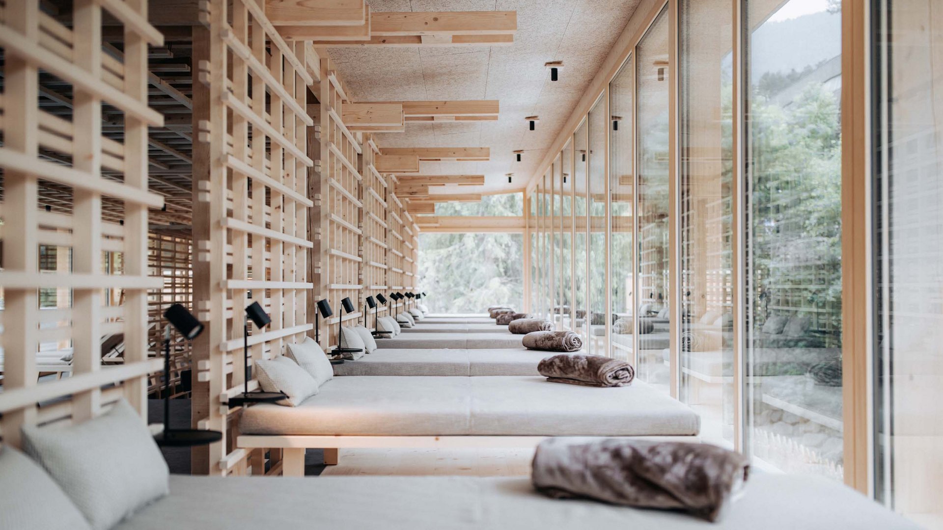 Größte Hochalm Europas – ein Kraftplatz mit Seele Ruheraum mit Liegen, Kissen und Decken neben großen Glasfenstern