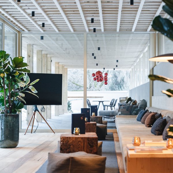 Sensoria Dolomites: Wellnesshotel in den Dolomiten Moderner Loungebereich mit Holzdecke, Sofas und großen Fenstern