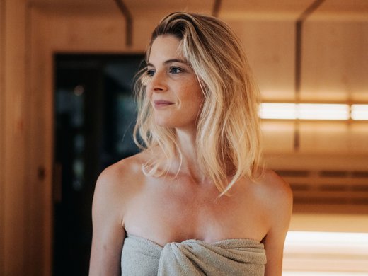 Day Spa in Südtirol – Wellness für die Seele Frau mit Handtuch in Holzzaun-Innensauna