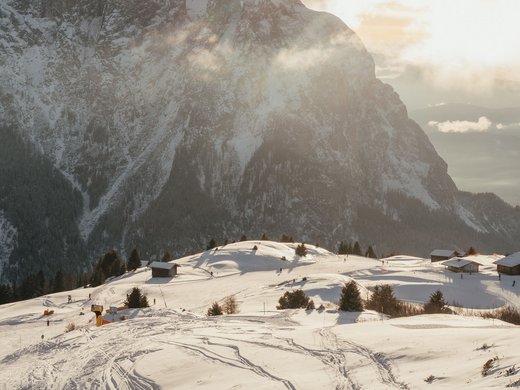 Inclusive services – last-minute South Tyrol holidays Snow-covered mountain landscape with ski tracks and sunset in the background