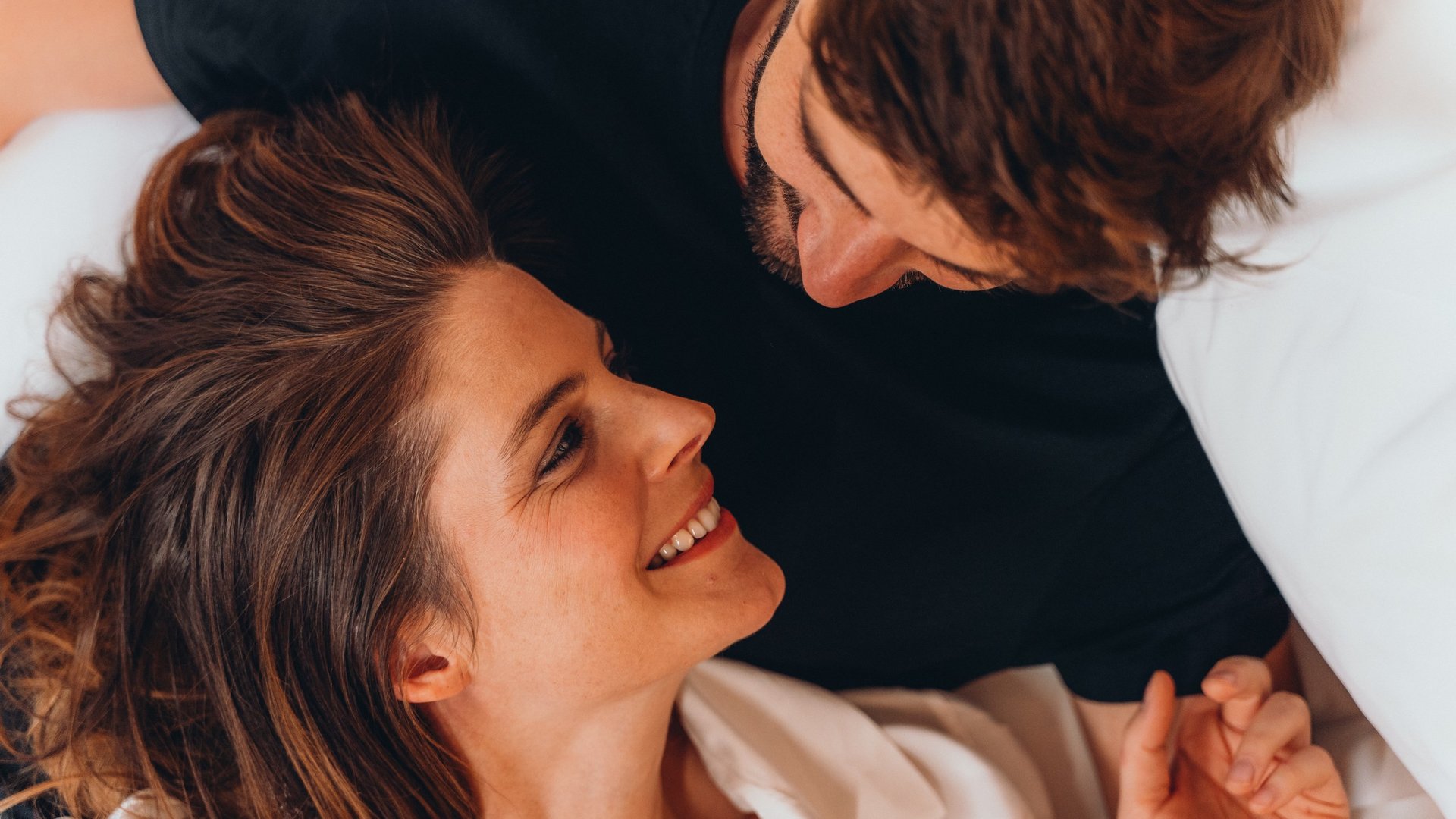 Größte Hochalm Europas – ein Kraftplatz mit Seele Paar liegt im Bett und schaut sich liebevoll an