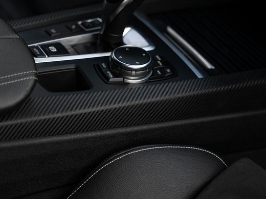 Anreise in Ihr Hotel an der Seiser Alm in Südtirol Schaltknauf und Steuerung im Inneren eines Autos mit schwarzem Leder und Carbonfaser