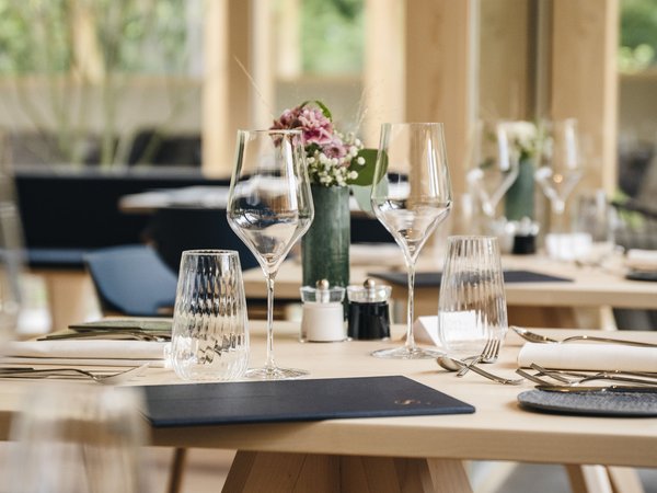 Wellness Aphrodite: Sensoria Dolomites unter den Siegern Eleganter gedeckter Esstisch mit Weingläsern und Blumenarrangement