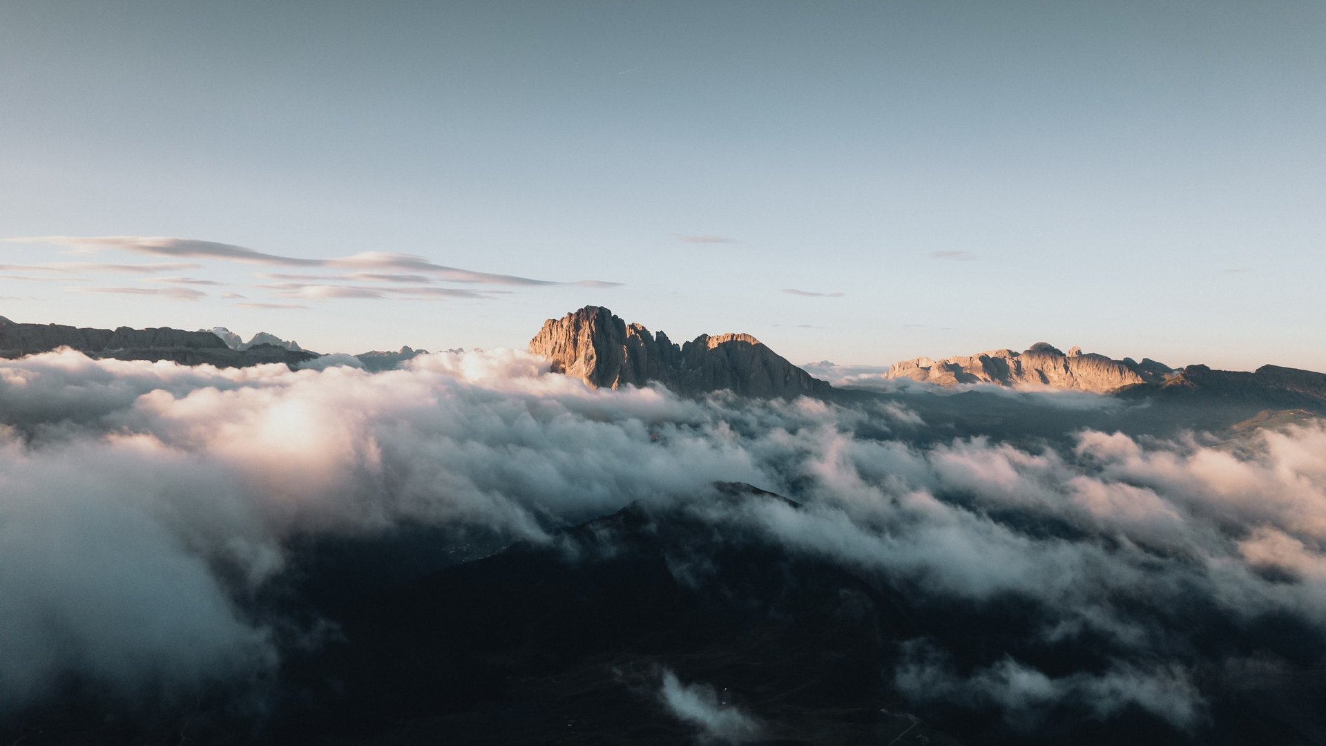 Urlaub in den Dolomiten – Urlaub im Sensoria Dolomites Berggipfel ragen aus Nebel unter klarem Himmel bei Sonnenaufgang
