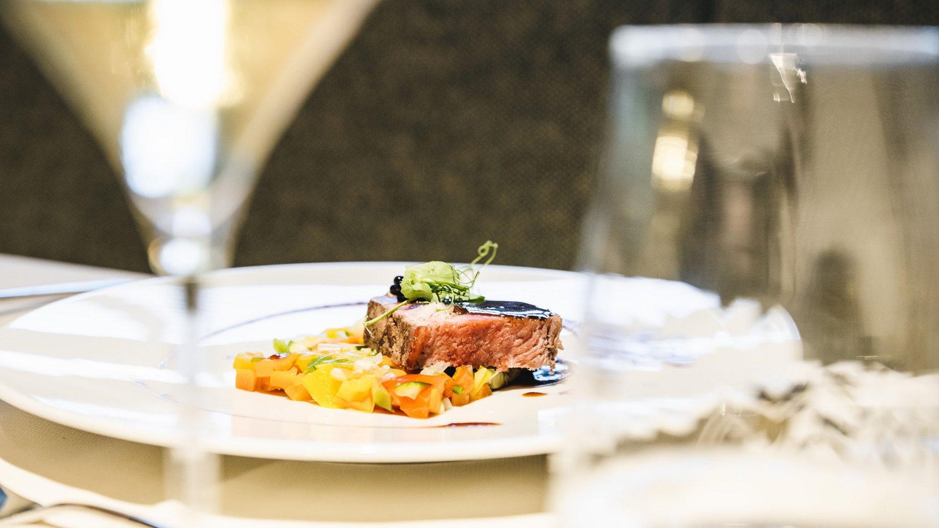 Genussurlaub in Südtirol – Sensoria Dolomites Gourmetgericht mit Fleisch und Gemüse auf weißem Teller