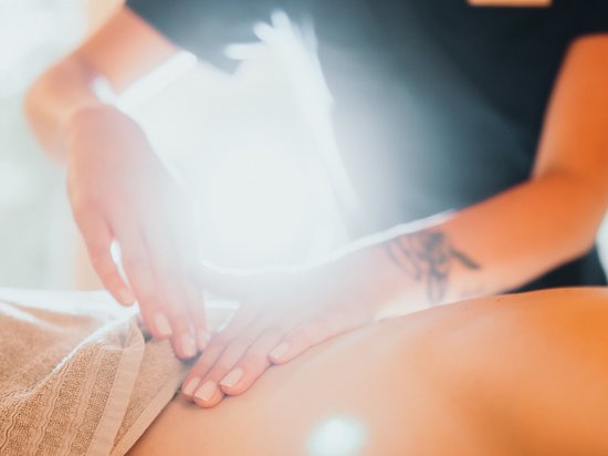 Spa-Wochenende für Paare – Treatments Person erhält sanfte Bauchmassage in hellem Raum