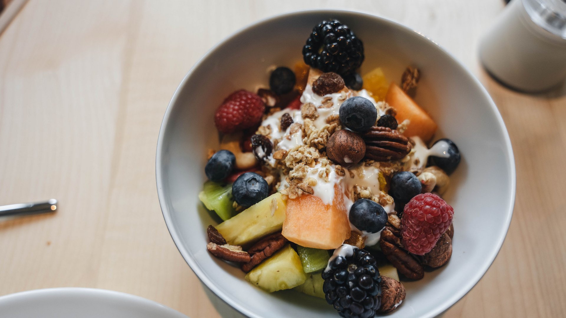 Inclusive services – last-minute South Tyrol holidays Bowl of fruit salad with yogurt, nuts, and berries on wooden table