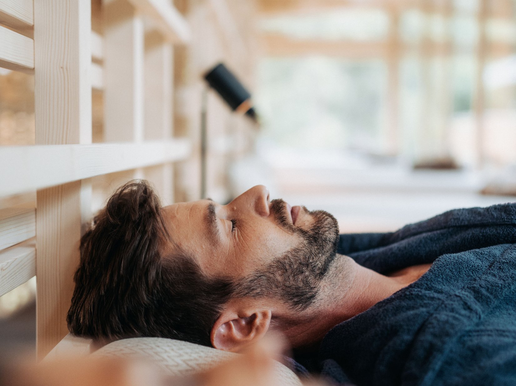 Luxus für die Seele: Ihr Adults-only-Hotel in Südtirol Mann entspannt in einem Spa mit geschlossenen Augen, liegt auf einer Liege