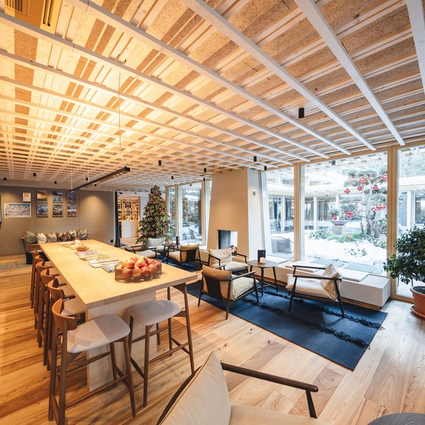 Sensoria Dolomites: Wellnesshotel in den Dolomiten Modernes Wohnzimmer mit Weihnachtsbaum und großem Holztisch
