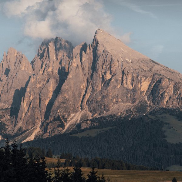 Nachhaltiges Handeln im Sensoria Dolomites Felsige Bergspitzen im Abendlicht mit Wolken am Himmel