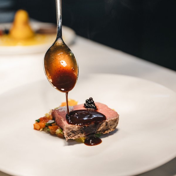 Your hotel in the Dolomites: Sensoria Dolomites Sauce poured on a slice of pink cooked meat with vegetables