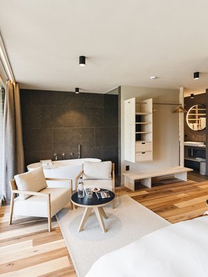 Sensoria Dolomites: Wellnesshotel in den Dolomiten Modernes Hotelzimmer mit Badewanne, Sitzbereich und großem Fenster