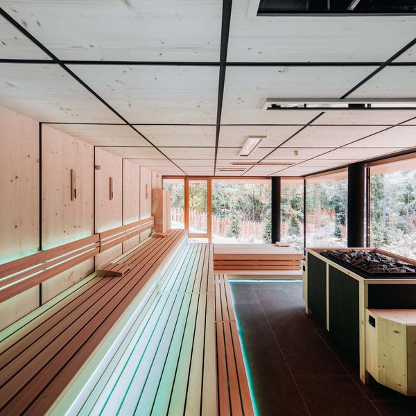 Your hotel in the Dolomites: Sensoria Dolomites Modern sauna room with large windows and wooden benches