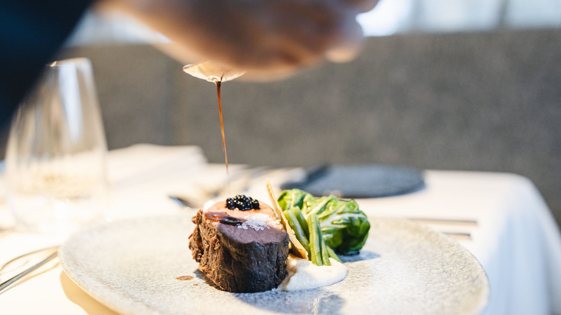 Your hotel in the Dolomites: Sensoria Dolomites Filet steak with sauce, green vegetables, and purée on plate
