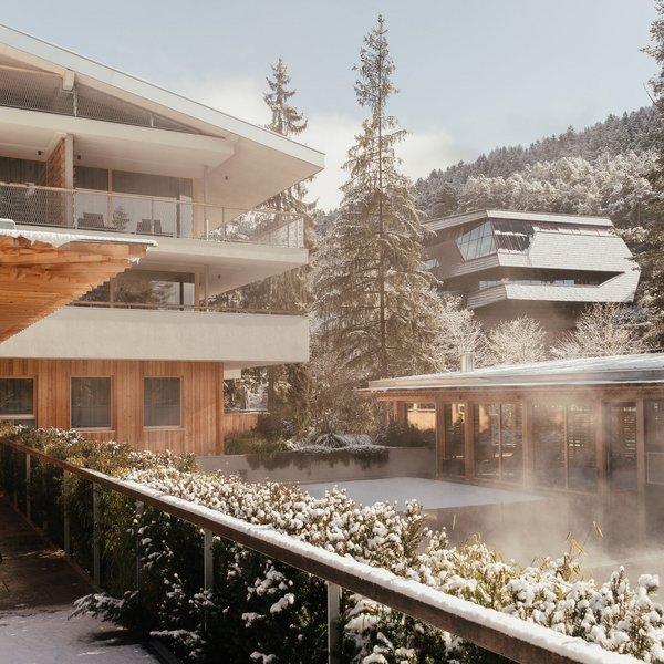 Sensoria Dolomites: Wellnesshotel in den Dolomiten Verschneites Hotel mit Terrasse und Bergen im Hintergrund