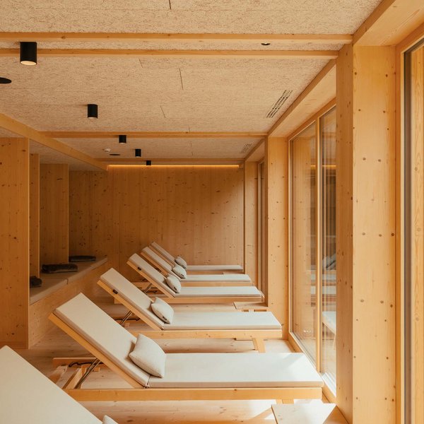 Your hotel in the Dolomites: Sensoria Dolomites Relaxation area with lounge chairs in wooden interior and large windows