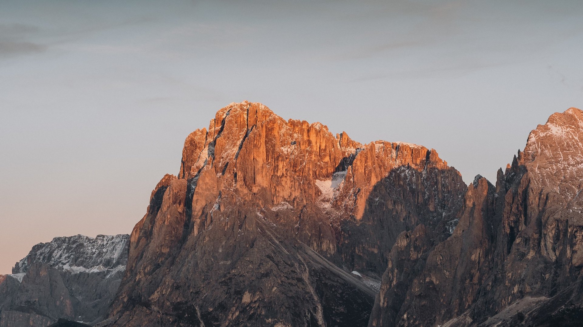 Holidays in the Dolomites – holidays at Sensoria Dolomites Mountain peaks lit by warm sunset light with light snow cover