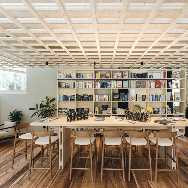 Your hotel in the Dolomites: Sensoria Dolomites Modern cozy reading area with long wooden table and bookshelf in background