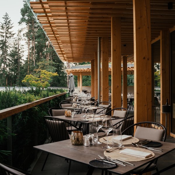 Your hotel in the Dolomites: Sensoria Dolomites Elegant outdoor restaurant terrace with set tables made of wood and metal