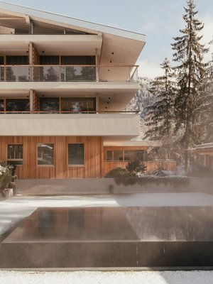 Sensoria Dolomites: Wellnesshotel in den Dolomiten Modernes Gebäude mit beheiztem Außenpool und verschneiter Landschaft